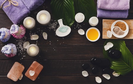 Spa treatment tools and aromatherapy concept background. Zen stones, aroma salt, spices, herbal balls, oil and soap, candle and details of wellness body care and alternative indian medicine, top viewの写真素材