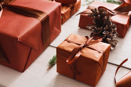 Gift wrapping background. Packaging stylish christmas present boxes in maroon paper decorated with...