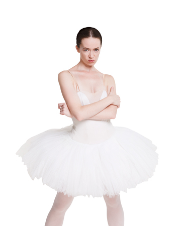 Angry naughty ballerina portrait against white background, isolated. Professional dancer in tutu skirt shows negative facial emotion. Choreography classes, bad behaviour conceptの写真素材