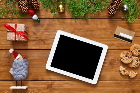 Christmas online shopping background. Tablet screen with copy space top view on wood, credit card and present boxes. Electronic devices, internet commerce on winter holidays conceptの写真素材