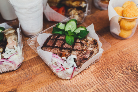 BBQ fresh grilled beef steak wrapped in paper on table. Picnic, street food on barbecue closeupの写真素材