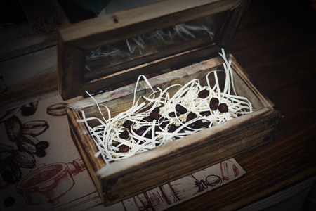 Roasted arabica coffee beans in wooden box. Aromatic scented seeds decorationの写真素材