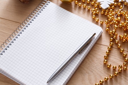 Christmas planning background. Prepare to winter holidays. Top view flat lay of xmas decorations, note papers, pen and mobile phone on wood. Copy space for wishlist or sheduleの写真素材