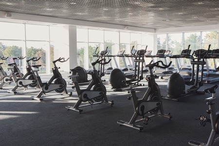 Modern gym interior with equipment, fitness exercise bikesの写真素材