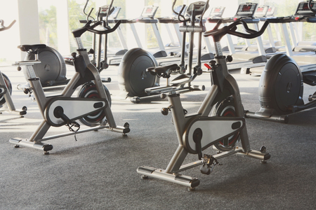 Modern gym interior with equipment, fitness exercise bikes