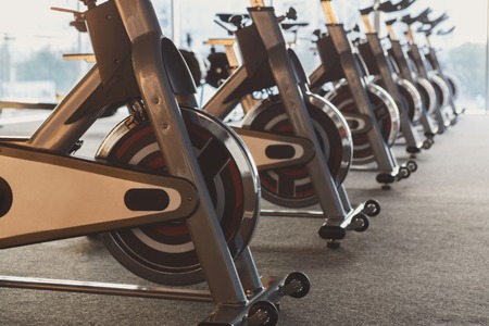 Modern gym interior with equipment, fitness exercise bikes
