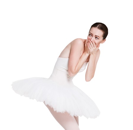 Confused laughing ballerina portrait against white background, isolated. Professional dancer in tutu skirt shows facial emotion, makes fun of someone. Choreography classesの写真素材