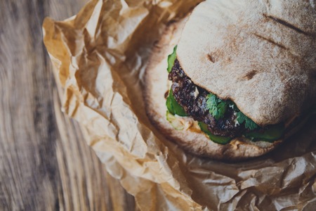 Classic american fast food background. Burger whole grain bun with grilled on barbecue meat and...