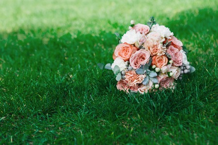Wedding background. Bouquet from rose flowers on grass. Bridal floral decoration detail outdoors in summer park, copy spaceの写真素材