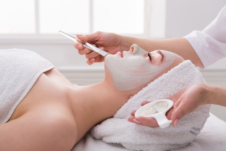 Face peeling mask, spa beauty treatment, skincare. Woman getting facial care by beautician at spa...