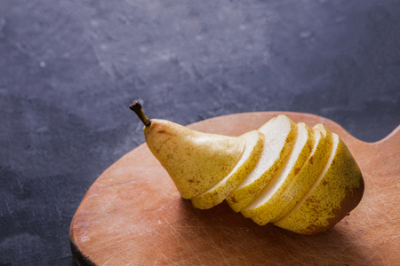 Healthy food, fruit background. Sliced pear on wooden board, selective focus, nobody, diet and vegetarian conceptの写真素材