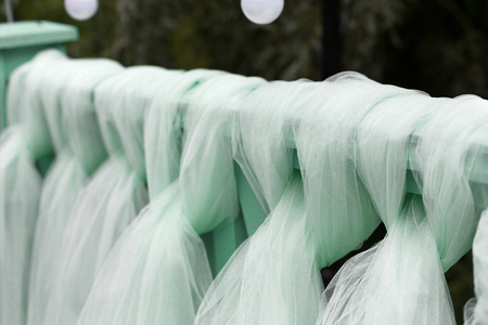 Wedding ceremony decor details, turquoise curtain on wooden background, outdoors, close-up, shallow depth of fieldの写真素材