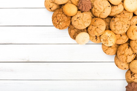 Cookies and biscuits sweets on white wood, background with copy space. Oatmeal and chocolate drops...