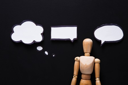 Handcrafted wooden man figure mannequin model dummy doll with blank speech bubble on black background,objects, nobodyの写真素材