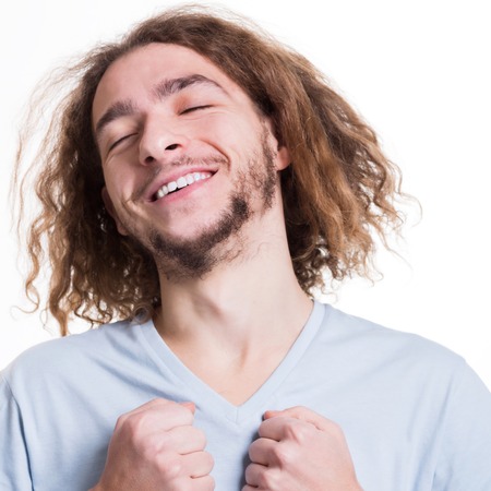 Great success. Excited man with happy facial expression smiling with closed eyes on white isolated studio backgroundの写真素材