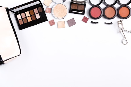 Makeup cosmetics and essentials frame on white background. Top view, flat lay with copy space. Beauty tools palettes collection, lipstick, eyeshadow, blush, foundation and moreの写真素材