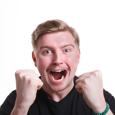 Winner celebrates. Great success. Excited man with happy facial expression shout on white isolated...