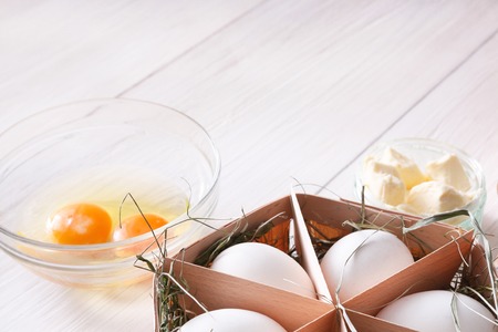 Baking background. Cooking ingredients for dough and pastry, eggs yolks, flour and cookie cutter on white rustic wood. Copy space, mockup for menu, recipe or culinary classes.の写真素材