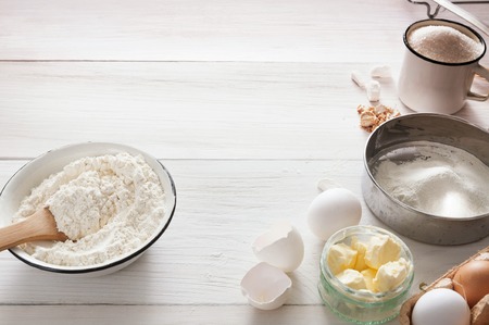Baking background. Cooking ingredients for dough and pastry, flour on white rustic wood. Copy space,...
