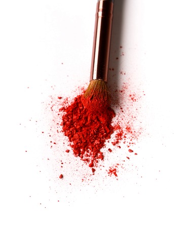 Makeup brush with red blush sprinkled on white. Make up and female cosmetics backgroundの写真素材