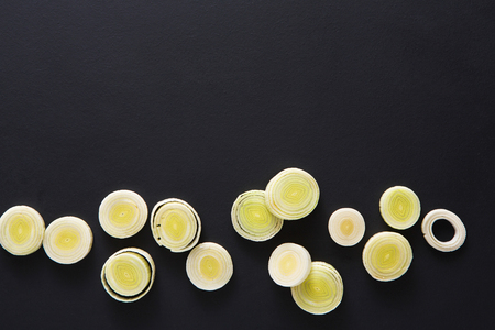 Cooking healthy food. Sliced leek border on dark backgroundの写真素材