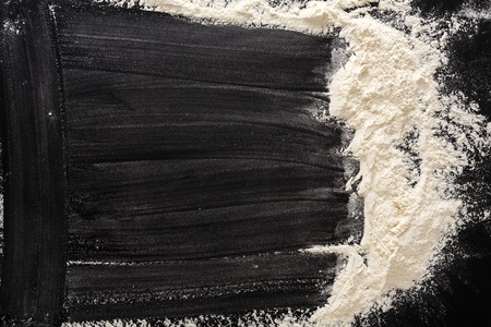 Flour on black, baking background with copy spaceの写真素材