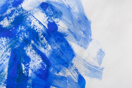 Watercolor paint brush blue strokes on paper texture, color spots on white abstract backgroundの写真素材