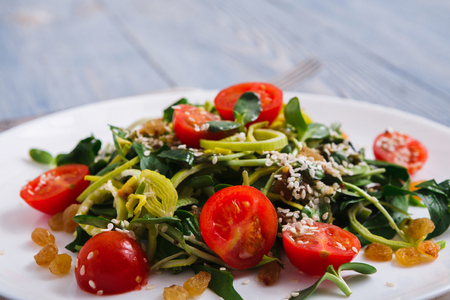 Restaurant healthy food, salad dish, served plate closeup. Mix with tomatoes and greenery on rustic wooden deskの写真素材
