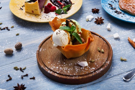 Ice cream served in waffle bowl. Three colored ice-cream scoops with mint, peanuts and chocolate...