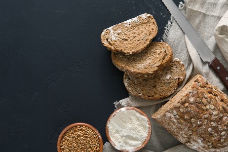 Bakery background, rye bread on black. Flour and grain with copy space
