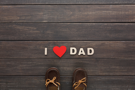 Happy Fathers Day, love dad background on rustic wood with child shoesの写真素材