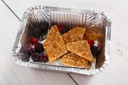 Healthy sweet snack. Berry and crackers in foil container closeupの写真素材