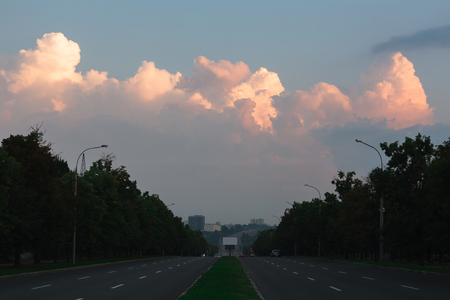 Countryside. Evening suburbian road with pink sunset clouds in skyの写真素材