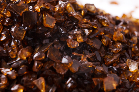 Heap of brown Amber stones on white background. Pile of natural gems, free space for text. Beauty, jewelry conceptの写真素材