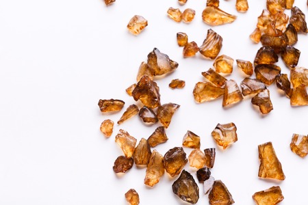 Brown Amber stones on white background. Pile of natural gems, free space for text. Beauty, jewelry conceptの写真素材