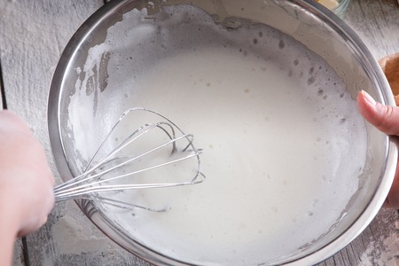 Kitchen, whisk dough with tool for whipping cream, metallic hand mixer closeup