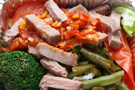 Healthy food background. Daily take away meals. Dietary restaurant food delivery. Steamed meat with vegetable salad and sauce in foil box, closeupの写真素材