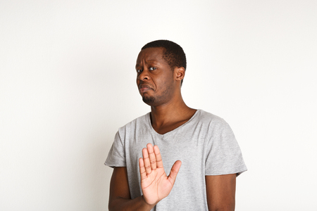 Black man expressing disapprovement, rejecting hand gesture, on white studio background. Negative emotionsの写真素材