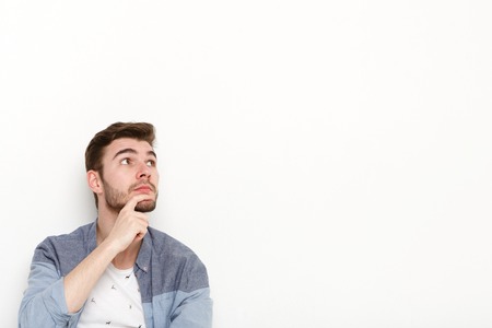 Thoughtful man dreaming, looking away. Young guy with pensive face lost in thoughts, isolated on...