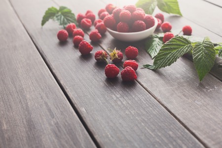Raspberries bowl on rustic wood background, copy space. Organic berries on wooden tableの写真素材