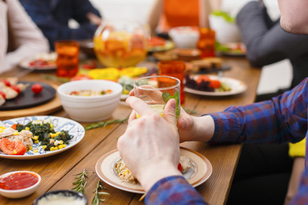 Served table for dinner. Hands with glass closeupの写真素材