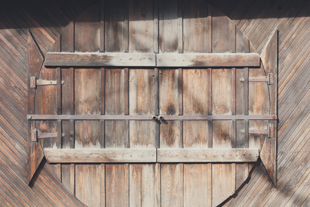 Natural wood round doors. Wooden planks wall with doors as background. Rustic, old wooden surface.の写真素材