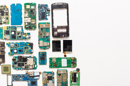Mobile repair flat lay background. Dissasembled smartphone top view, copy space. Technician workplace with instruments and cell phone componentsの写真素材