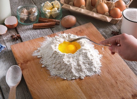 Baking concept. Flour, milk, butter, yeast, spices and eggs carton on rustic wooden table, cooking...