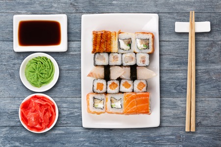 Japanese food restaurant delivery - sushi maki, unagi and roll platter set isolated on blue wood background, above viewの写真素材