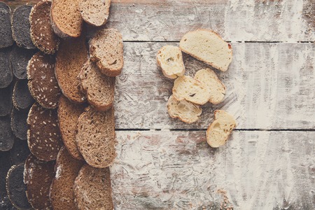 Sliced sorts of bread gradient background. Bakery and grocery concept with copy space. Black, rye and white loavesの写真素材