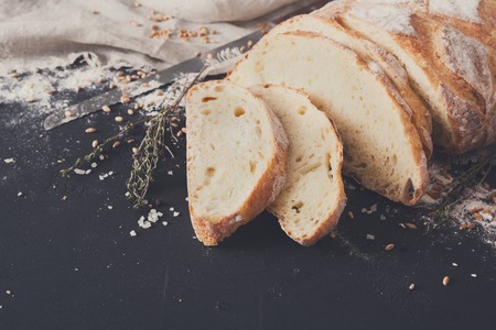 Bakery background, sliced white bread on black. Flour and grain with copy space