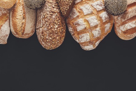 Bakery background, bread sorts border isolated on black. Top view with copy spaceの写真素材