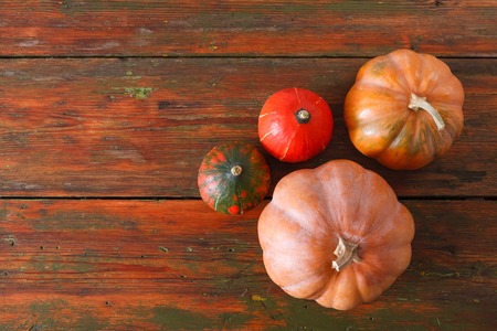 Fall background. Top view, pumpkins on weathered rustic red wood with copy space.の写真素材