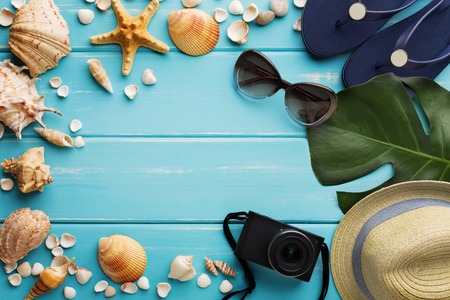 Vacation background on blue wood, top view with copy space. Beach accessories, flip flops,...